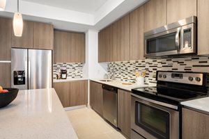 A modern kitchen with wooden cabinets and stainless steel appliances.